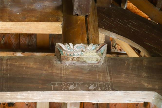 Kết cấu hoành, xà nâng mái của ngôi nhà sàn được trang trí bằng hình tượng đài sen cách điệu. Ảnh: Xuân Tiến - TTXVN 
