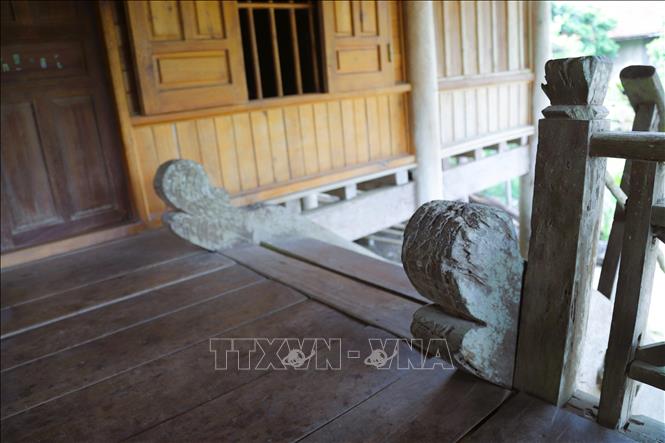 Đầu cầu thang của ngôi nhà sàn cổ của đồng bào Thái ở xã Bình Chuẩn (tỉnh Nghệ An) được tạo tác mang hình đầu rồng cách điệu, thể hiện sự uy. Ảnh: Xuân Tiến - TTXVN 