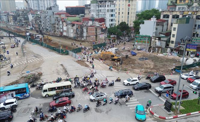 Hhướng từ Nguyễn Chí Thanh đi Nguyên Hồng, xe máy và phương tiện thô sơ sẽ di chuyển theo hệ thống biển chỉ dẫn vào tuyến đường tạm được bố trí sát khu vực rào chắn. Tuyến đường này có mặt cắt rộng khoảng 7m, được thi công bằng kết cấu bê-tông nhằm bảo đảm an toàn cho người tham gia giao thông. Ảnh: Quốc Khánh - TTXVN