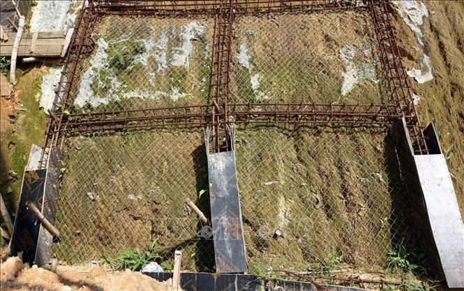 Một số hạng mục gia cố taluy vẫn thi công dang dở, để lộ cốt thép. Ảnh: Tạ Toàn - TTXVN