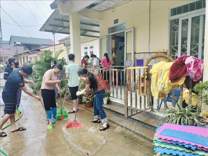Người dân tham gia dọn dẹp sau mưa lớn tại Trường Mầm non và Tiểu học Minh Long, xã Lý Quốc. Ảnh: TTXVN phát
