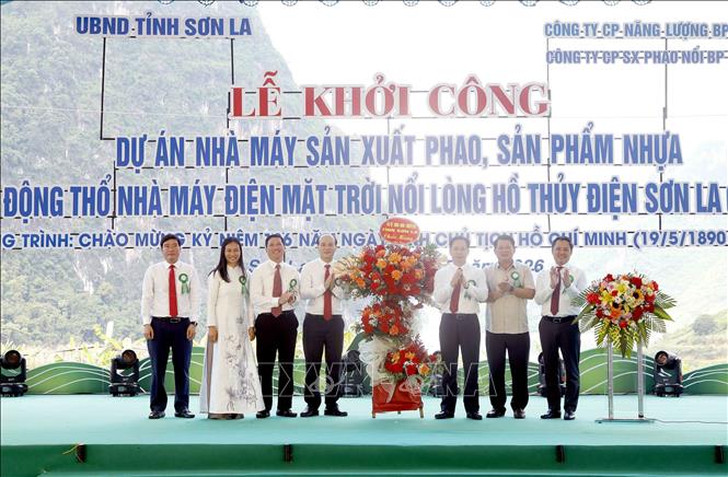Lãnh đạo tỉnh Sơn La (bên phải) tặng hoa chúc mừng các đơn vị thuộc dự án. Ảnh: Quang Quyết - TTXVN