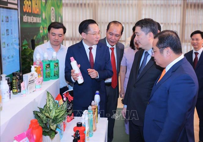 Thứ trưởng Bộ Tài chính Cao Anh Tuấn và lãnh đạo Tập đoàn Hoá chất Việt Nam tham quan triển lãm các sản phẩm của các đơn vị thành viên thuộc Tập đoàn Hoá chất Việt Nam. Ảnh: Hoàng Hiếu - TTXVN
