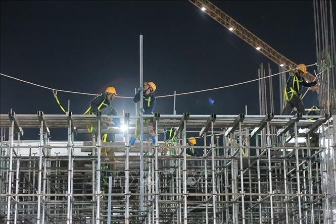 Các tổ thợ khẩn trương lắp dựng hệ giàn giáo và vận chuyển thép hộp phục vụ thi công công trình. Ảnh: Lê Đông - TTXVN 