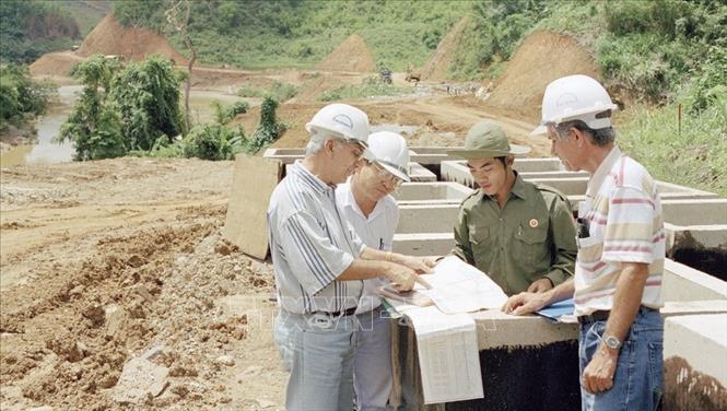 Sau ngày đất nước thống nhất, đường Trường Sơn - đường Hồ Chí Minh mang sứ mệnh lịch sử mới - tuyến đường công nghiệp hóa, hiện đại hóa, trở thành tuyến quốc lộ xuyên Việt hiện đại thứ hai phía Tây đất nước, phục vụ cho thời kỳ hội nhập, phát triển và củng cố an ninh quốc phòng của đất nước. Ảnh: TTXVN Kỹ sư tư vấn của Cuba cùng cán bộ điều hành lực lượng thanh niên tiến hành đánh giá kết quả thi công nền đường Hồ Chí Minh, đoạn Hiên - Thạnh Mỹ, tỉnh Quảng Nam. Ảnh: Đình Na - TTXVN
