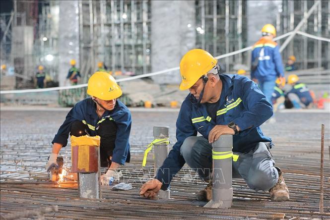 Công nhân thi công làm việc xuyên đêm tại công trường. Ảnh: Lê Đông - TTXVN 