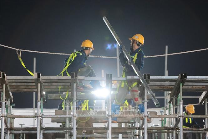 Các tổ thợ khẩn trương lắp dựng hệ giàn giáo và vận chuyển thép hộp phục vụ thi công công trình. Ảnh: Lê Đông - TTXVN 