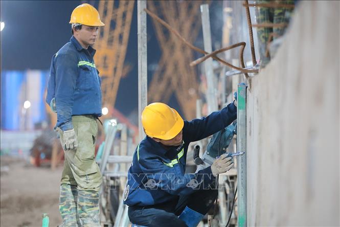 Công nhân thi công làm việc xuyên đêm tại công trường. Ảnh: Lê Đông - TTXVN 