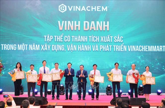 Chủ tịch Hội đồng thành viên Tập đoàn Hoá chất Việt Nam Phùng Quang Hiệp và Tổng giám đốc Tập đoàn Hoá chất Việt Nam Nguyễn Hữu Tú tặng Giấy khen và hoa cho các tập thể đạt thành tích của Sàn thương mại điện tử Vinachemmart. Ảnh: Hoàng Hiếu - TTXVN