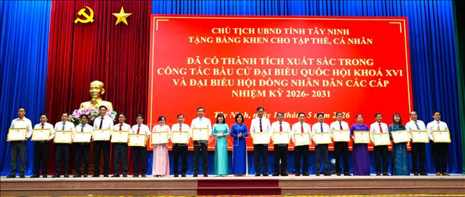 Bà Nguyễn Thị Xuân Hương, Trưởng Ban Tuyên giáo và Dân vận Tỉnh ủy Tây Ninh trao Bằng khen cho các tập thể đã đạt thành tích xuất sắc trong công tác Bấu cử Quốc hội và HĐND các cấp nhiệm kỳ 2026-2031. Ảnh: Thanh Bình - TTXVN