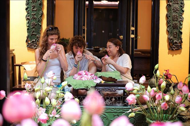 Foreign visitors experience the fragrance of lotus flowers. VNA Photo: Phạm Tuấn Anh