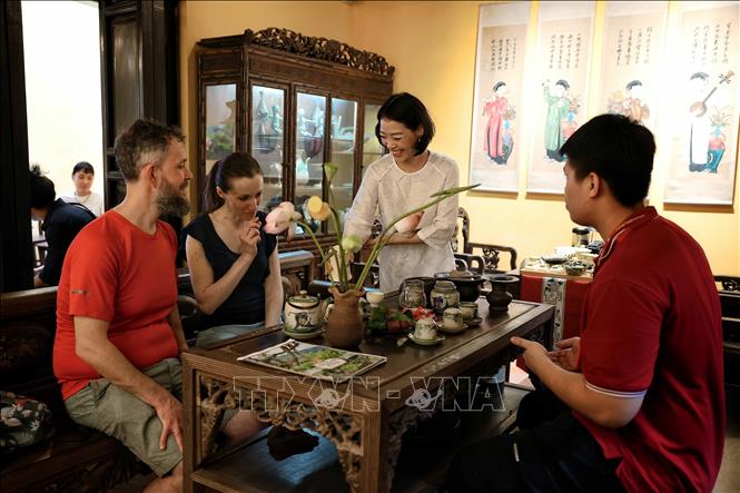 International tourists experience the tea-drinking atmosphere and learn about the traditional lotus tea art at the Heritage House, 87 Ma May Street, Hanoi. VNA Photo: Phạm Tuấn Anh