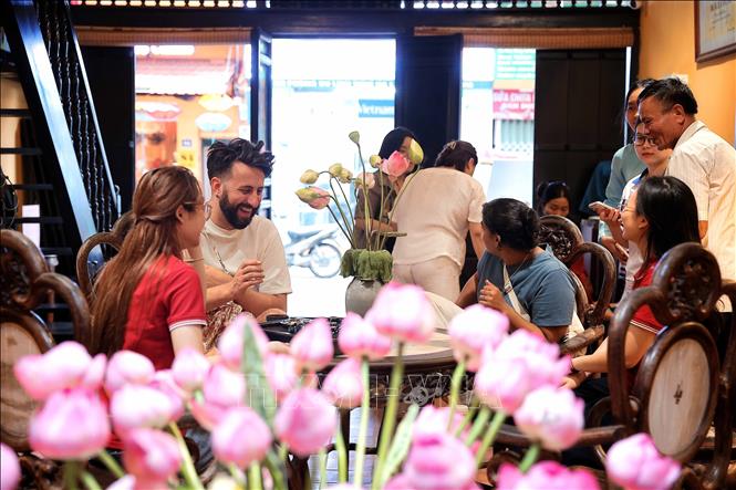 International tourists experience the tea-drinking atmosphere and learn about the traditional lotus tea art at the Heritage House, 87 Ma May Street, Hanoi. VNA Photo: Phạm Tuấn Anh