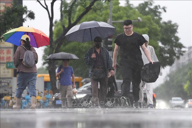 Người dân di chuyển dưới trời mưa tại Bắc Kinh, Trung Quốc ngày 17/5/2026. Ảnh: THX/TTXVN
