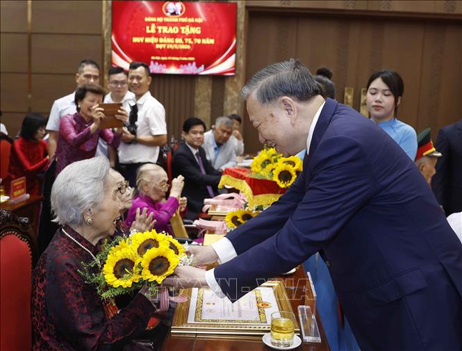 Tổng Bí thư, Chủ tịch nước Tô Lâm tặng hoa chúc mừng các đảng viên nhận Huy hiệu Đảng. Ảnh: Thống Nhất – TTXVN