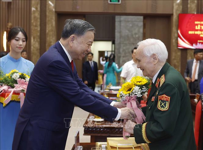 Tổng Bí thư, Chủ tịch nước Tô Lâm tặng hoa chúc mừng các đảng viên nhận Huy hiệu Đảng. Ảnh: Thống Nhất – TTXVN