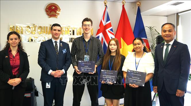 Đại sứ Việt Nam tại New Zealand Phan Minh Giang (phải) trao tặng giải thưởng cho các đại biểu sinh viên đạt thành tích xuất sắc tại NZMAM 2026. Ảnh: TTXVN phát