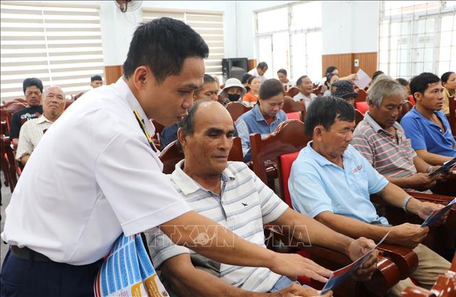 Tuyên truyền bà con các quy định về phòng chống khai thác hải sản bất hợp pháp. Ảnh: Đinh Hương - TTXVN