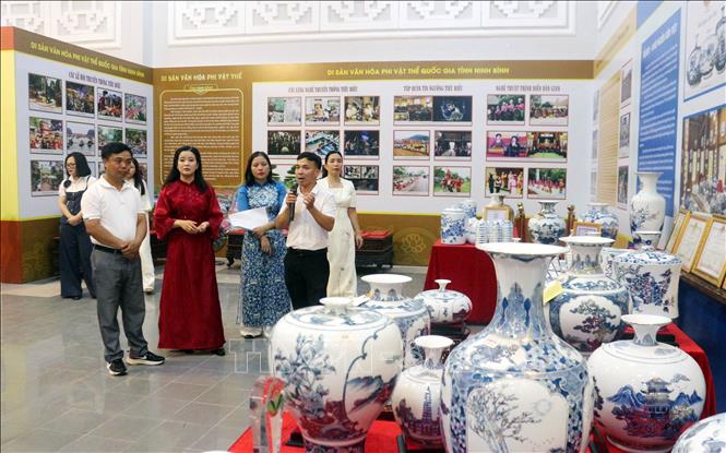Các đại biểu, nhân dân, học sinh tham quan không gian trưng bày giới thiệu về di sản văn hóa tiêu biểu tỉnh Ninh Bình. Ảnh: Thanh Tuấn - TTXVN