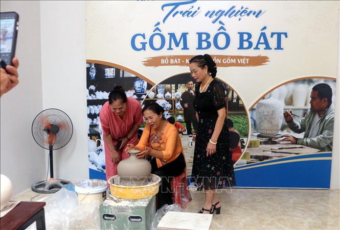 Người dân trải nghiệm làm gốm Bồ Bát tại trưng bày. Ảnh: Thanh Tuấn - TTXVN