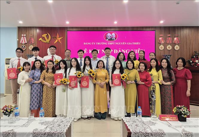 Đại diện Ban Giám hiệu và giáo viên Trường THPT Nguyễn Gia Thiều (phường Bồ Đề, Hà Nội) chúc mừng các đảng viên trẻ. Ảnh: Nguyễn Cúc-TTXVN