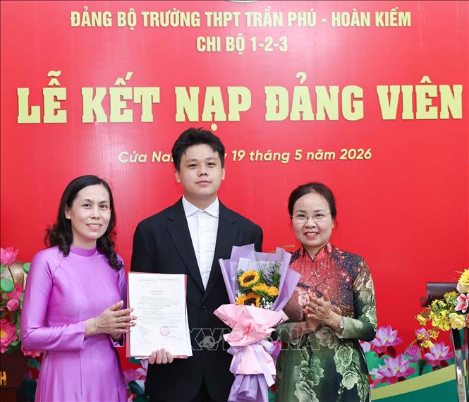 Trao quyết định kết nạp Đảng và tặng hoa chúc mừng các quần chúng ưu tú là học sinh của trường THPT Trần Phú - Hoàn Kiếm. Ảnh: Thanh Tùng - TTXVN