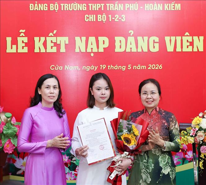 Trao quyết định kết nạp Đảng và tặng hoa chúc mừng các quần chúng ưu tú là học sinh của trường THPT Trần Phú - Hoàn Kiếm. Ảnh: Thanh Tùng - TTXVN