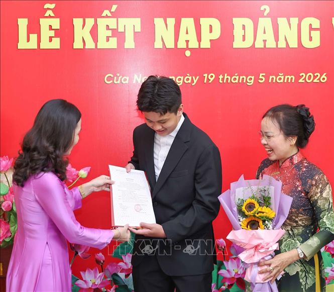 Trao quyết định kết nạp Đảng và tặng hoa chúc mừng các quần chúng ưu tú là học sinh của trường THPT Trần Phú - Hoàn Kiếm. Ảnh: Thanh Tùng - TTXVN