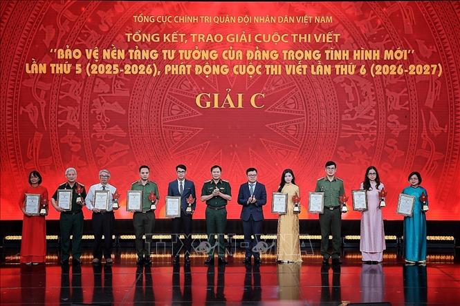 Đại tướng Nguyễn Tân Cương, Ủy viên Trung ương Đảng, Ủy viên Thường vụ Quân ủy Trung ương, Tổng Tham mưu trưởng, Thứ trưởng Bộ Quốc phòng và ông Lê Quốc Minh, Uỷ viên Trung ương Đảng, Tổng Biên tập Báo Nhân Dân, Chủ tịch Hội Nhà báo Việt Nam, Phó Trưởng Ban Tuyên giáo và Dân vận Trung ương trao giải C cho các tác giả đoạt giải. Ảnh: Phạm Tuấn Anh - TTXVN
