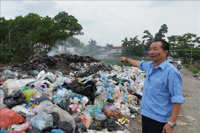 Ông Nguyễn Tuấn Hưng, người dân thôn Đông Mai, xã Lạc Đạo bức xúc trước tình trạng đốt rác trái quy định gây ô nhiễm môi trường. Ảnh Mạnh Khánh-TTXVN