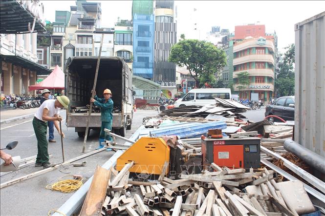 Công nhân tháo dỡ, di chuyển rào chắn khỏi khu vực thi công dự án bể ngầm chợ Hàng Da. Ảnh: Nguyễn Thắng - TTXVN