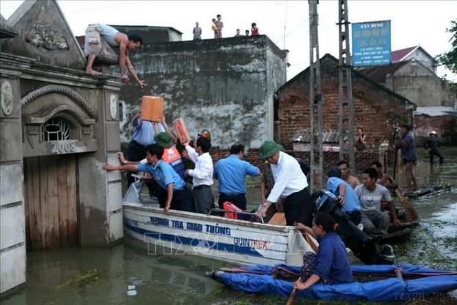 Trao hàng cứu trợ đến nhân dân vùng ngập lụt xã Nam Phương Tiến, huyện Chương Mỹ (Hà Nội) (11/2008). Ảnh: Xuân Trường – TTXVN