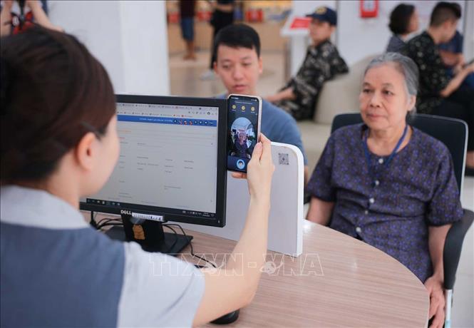 Nhân viên cửa hàng Viettel - 53 Lương Văn Can (Hà Nội) chụp ảnh xác thực thuê bao chính chủ cho khách hàng lớn tuổi. Ảnh: Hoàng Hiếu - TTXVN