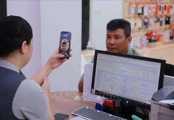 Nhân viên cửa hàng Viettel - 53 Lương Văn Can (Hà Nội) chụp ảnh xác thực thuê bao chính chủ khách hàng. Ảnh: Hoàng Hiếu - TTXVN