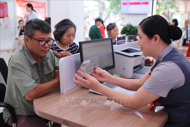 Nhân viên cửa hàng Viettel - 53 Lương Văn Can (Hà Nội) hỗ trợ khách hàng xác thực thuê bao chính chủ. Ảnh: Hoàng Hiếu - TTXVN