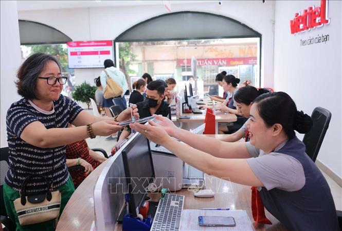 Mất khoảng 5 phút, khách hàng  đã tiến hành xác thực thuê bao chính chủ thành công tại cửa hàng Viettel. Ảnh: Hoàng Hiếu - TTXVN