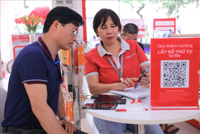 Để đảm bảo việc hỗ trợ trực tiếp khách hàng xác thực/thay đổi thông tin thuê bao điện thoại nhanh chóng, tại cửa hàng Viettel Store - số 1 đường Giải Phóng (Hà Nội) đã bố trí thêm cán bộ kinh doanh hỗ trợ khách hàng. Ảnh: Hoàng Hiếu - TTXVN