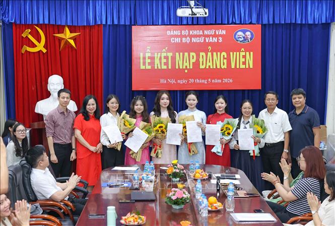 Lãnh đạo Đảng uỷ Khoa Ngữ văn tặng hoa chúc mừng 6 đảng viên mới được kết nạp của Chi bộ Ngữ văn 3. Ảnh: Thanh Tùng - TTXVN 