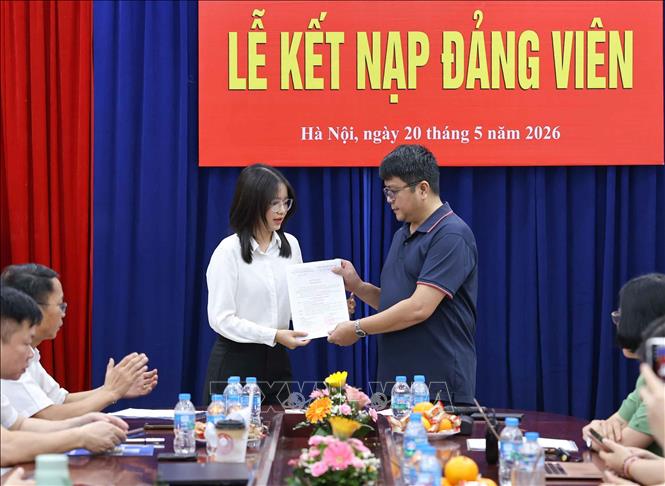 Bí thư Chi bộ Ngữ văn 3 trao quyết định kết nạp cho đảng viên mới. Ảnh: Thanh Tùng - TTXVN