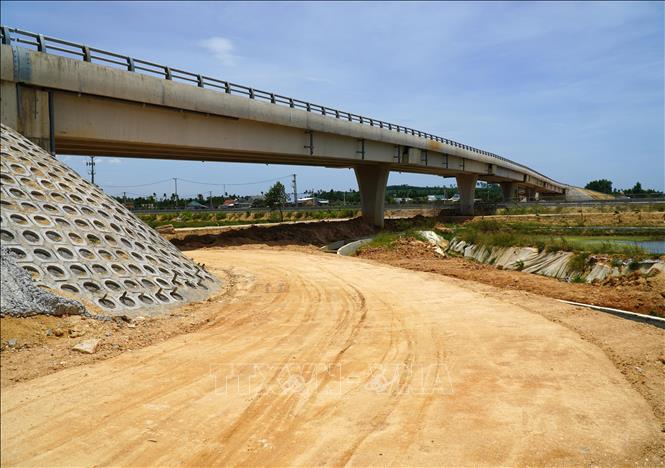 Sau kiến nghị, nhà thầu thi công chỉ hoàn trả đoạn đường đất men dọc theo cầu vượt khiến việc đi lại của người dân gặp nhiều trở ngại, nhất là vào mùa mưa. Ảnh: Lê Phước Ngọc-TTXVN
