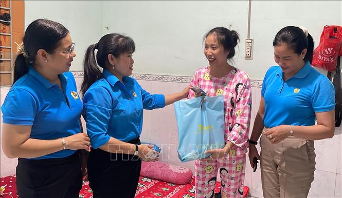 Phó Chủ tịch Liên đoàn Lao động tỉnh Vĩnh Long Võ Thị Thu Oanh trao quà cho công nhân đang ở trọ. Ảnh: Thanh Hòa - TTXVN