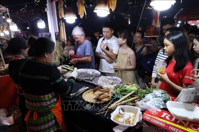 Visitors enjoy food at the event. VNA Photo: Trần Lê Lâm