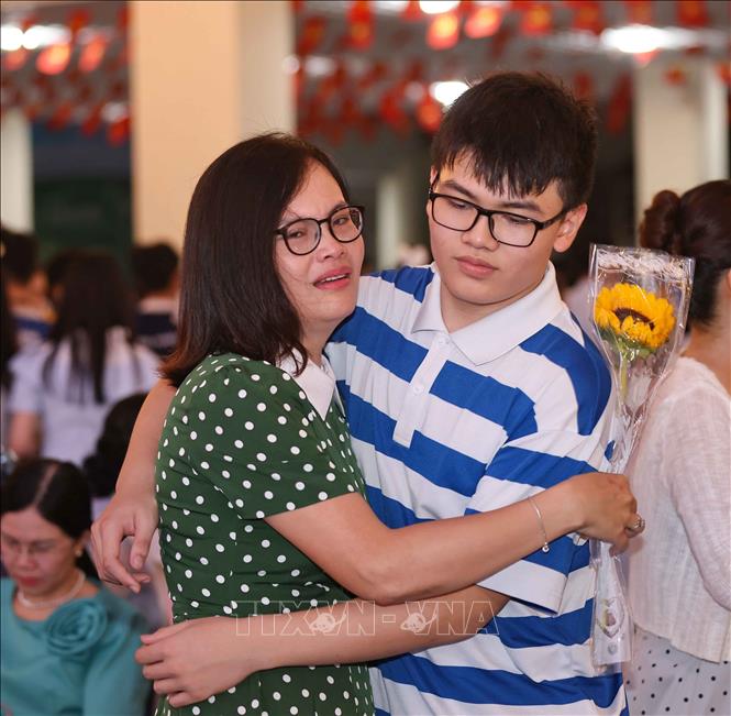 Giây phút xúc động khi học sinh khối 9 với bông hoa trên tay nói lời cảm ơn cha, mẹ. Ảnh: Thanh Tùng - TTXVN 
