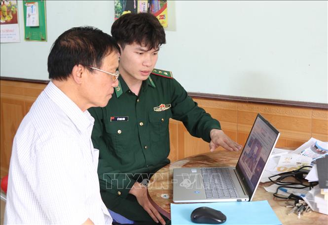 Cán bộ Đồn Biên phòng cửa khẩu Chi Ma, tỉnh Lạng Sơn, chỉ dẫn người dân nhận biết các website thông tin chính thống. Ảnh: Quang Duy – TTXVN