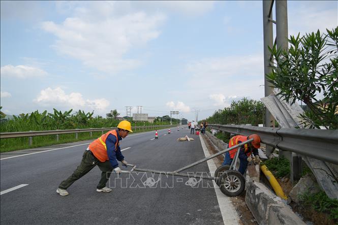 Thi công lắp ráp hộ lan trên tuyến Cao tốc Nội Bài- Lào Cai mở rộn. Ảnh: Hồng Ninh-TTXVN