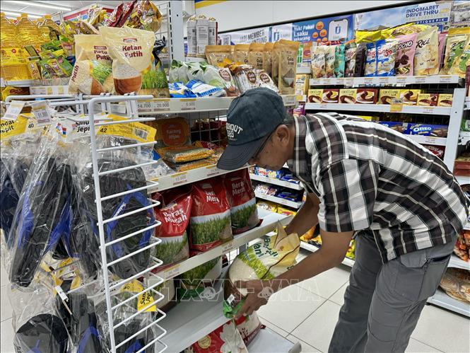 Một người dân chọn mua gạo tại siêu thị IndoMaret ở Jakarta. Ảnh: Đỗ Quyên - PV TTXVN tại Indonesia