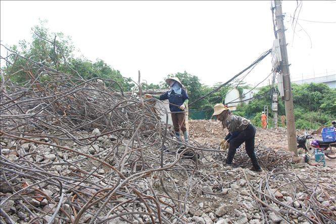 Người dân thu dọn đồ đạc, tận dụng nguyên vật liệu còn dùng được trong khu giải phóng mặt bằng. Ảnh: Nguyễn Thắng - TTXVN
