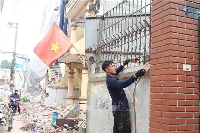 Người dân tháo dỡ hàng rào bàn giao mặt bằng cho đơn vị thi công. Ảnh: Nguyễn Thắng - TTXVN