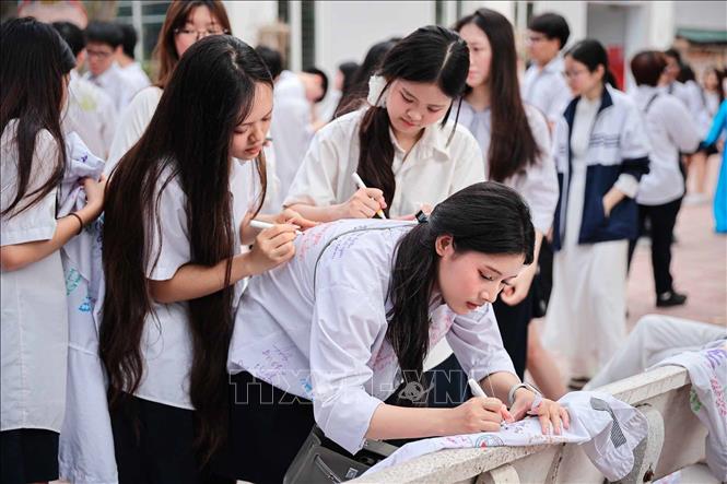 Những dòng lưu bút cuối cùng lên áo đồng phục gửi gắm yêu thương, lời chúc dành cho những người bạn. Ảnh: Phạm Tuấn Anh - TTXVN