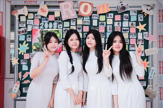 Nhóm nữ sinh bên bảng lưu giữ hình ảnh và lời nhắn của lớp học. Ảnh: Phạm Tuấn Anh - TTXVN